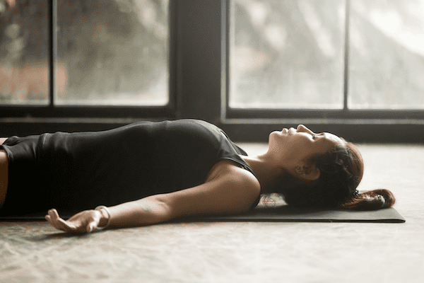 A woman using Prana Nidra as a yoga technique for muscular dystrophy