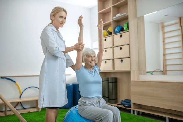 After receiving her yoga certification for occupational therapists, this OT helps an elderly patient stretch with yoga