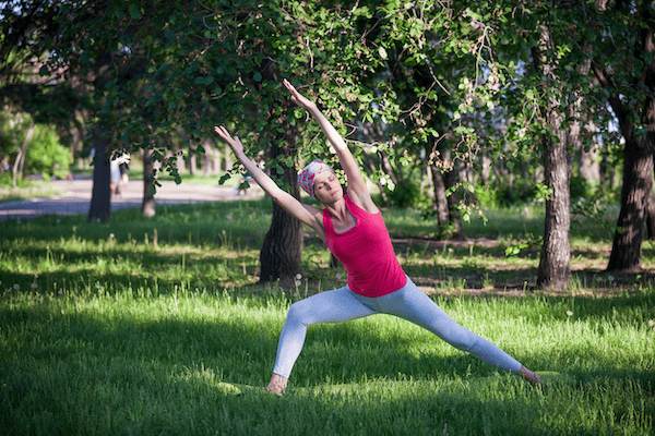 A cancer patient safely stretches outside after working with a yoga therapist who has received yoga cancer training