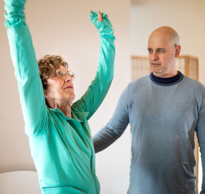 Our founder working with a student to teach about yoga therapy for back pain