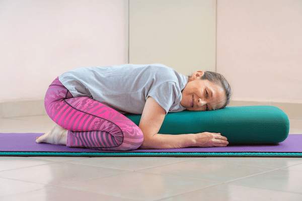 Instead of doing yoga on carpet, you can use two yoga mats like this woman or an extra thick yoga mat to provide enough cushion